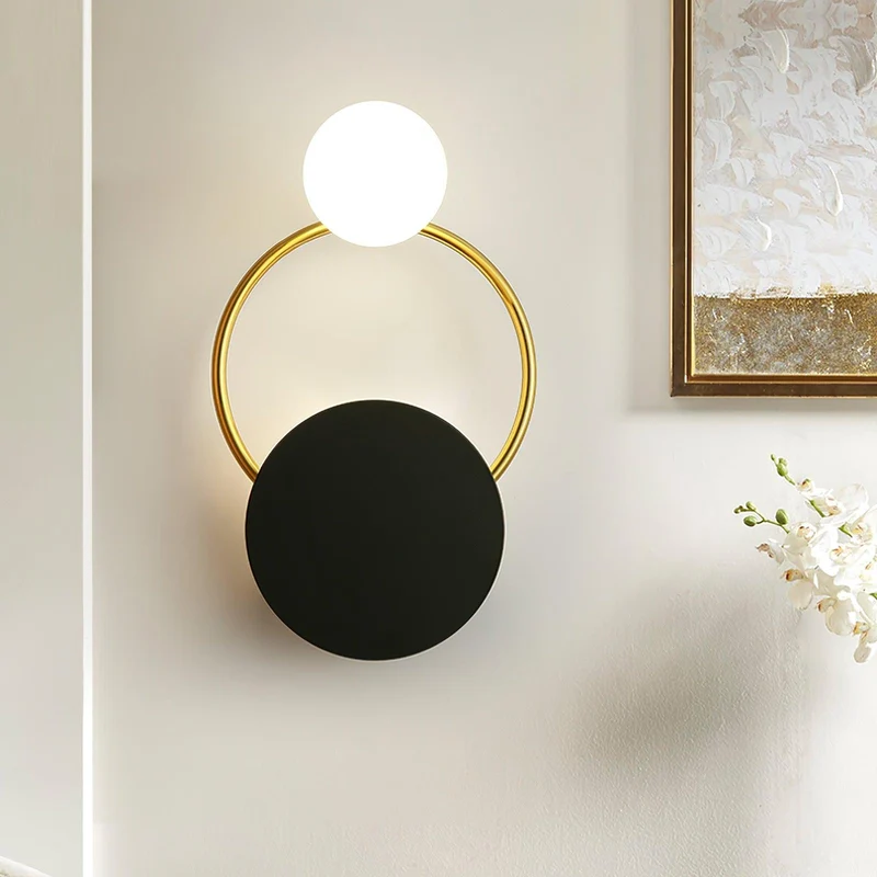 Elegant væglampe i guld og sort med unik glaskugle